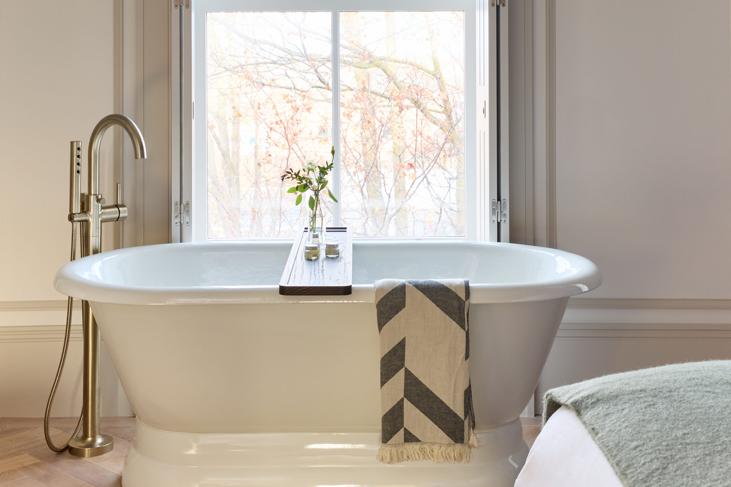 white stand alone bathtub in front of a window with a view