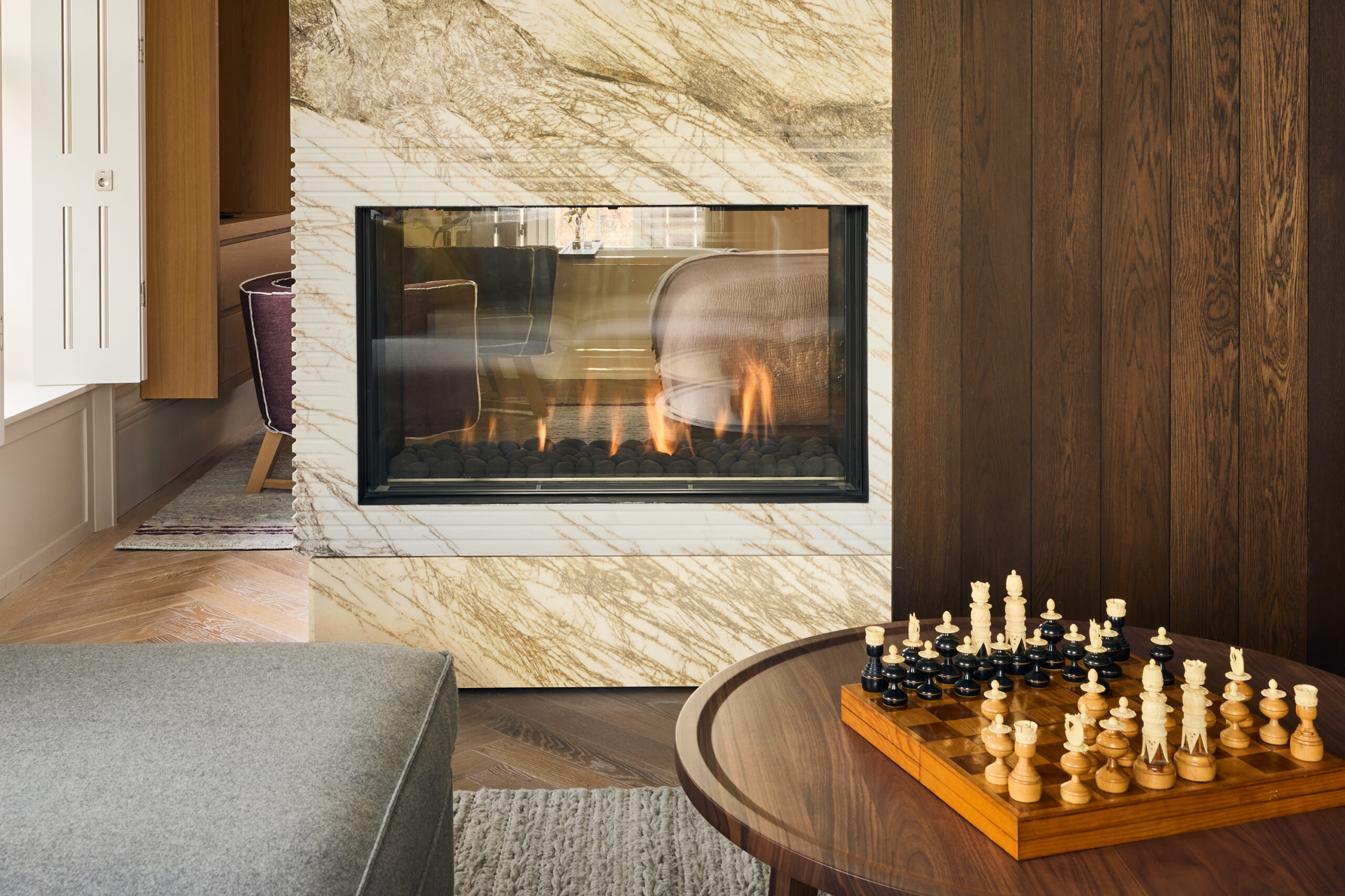 lit fireplace with coffee table and game of chess on it