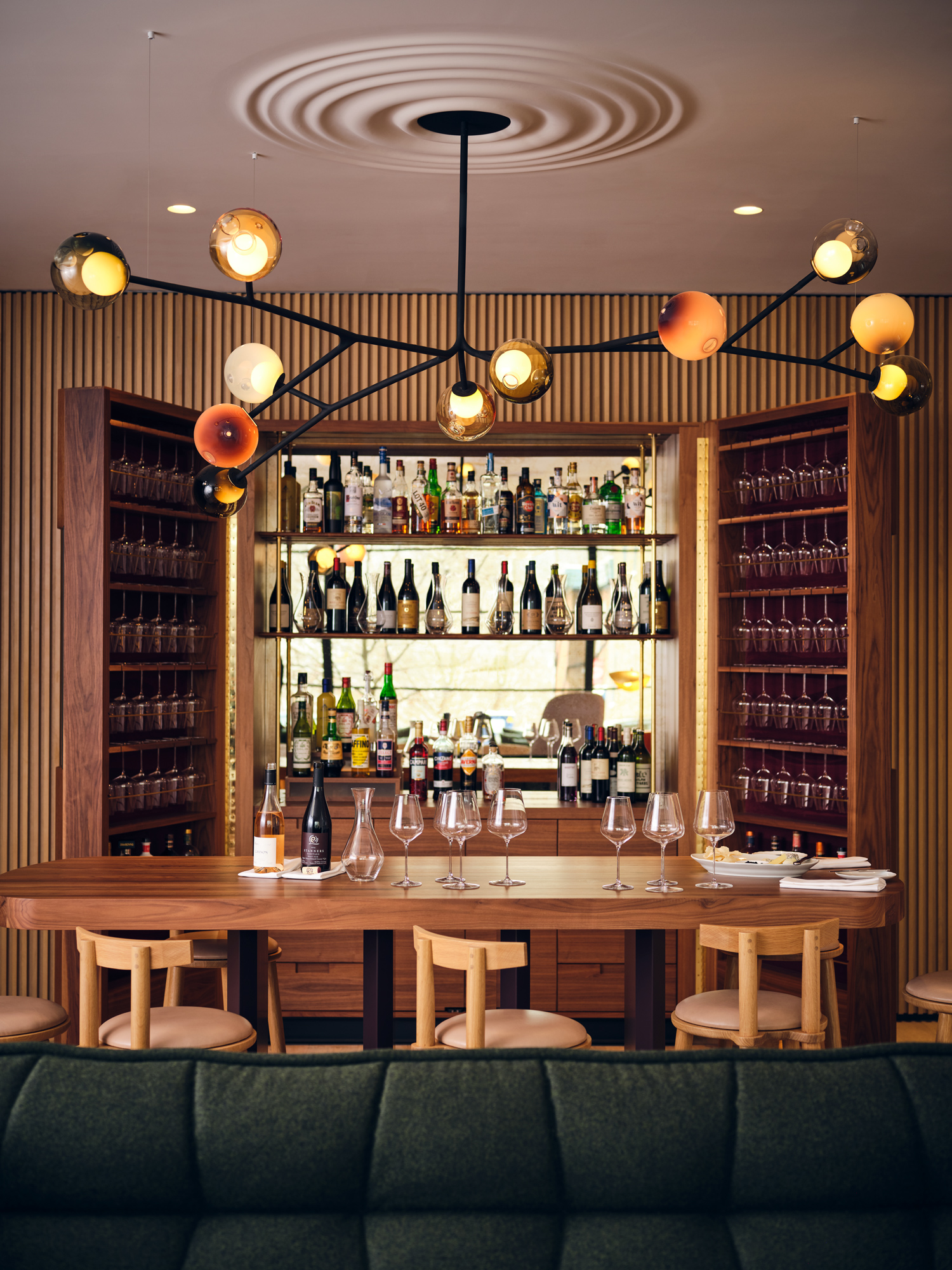 Welcoming bar with stools, beautiful light fixture overhead